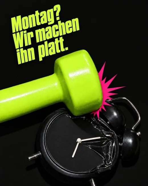 Eine neongrüne Hantel zerschlägt einen schwarzen Wecker, darüber steht „Montag? Wir machen ihn platt.“